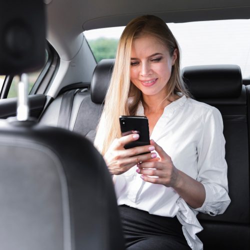 geschaeftsfrau-die-in-einem-auto-sitzt-und-das-telefon-betrachtet_23-2148266243 geschaeftsfrau-die-in-einem-auto-sitzt-und-das-telefon-betrachtet_23-2148266243